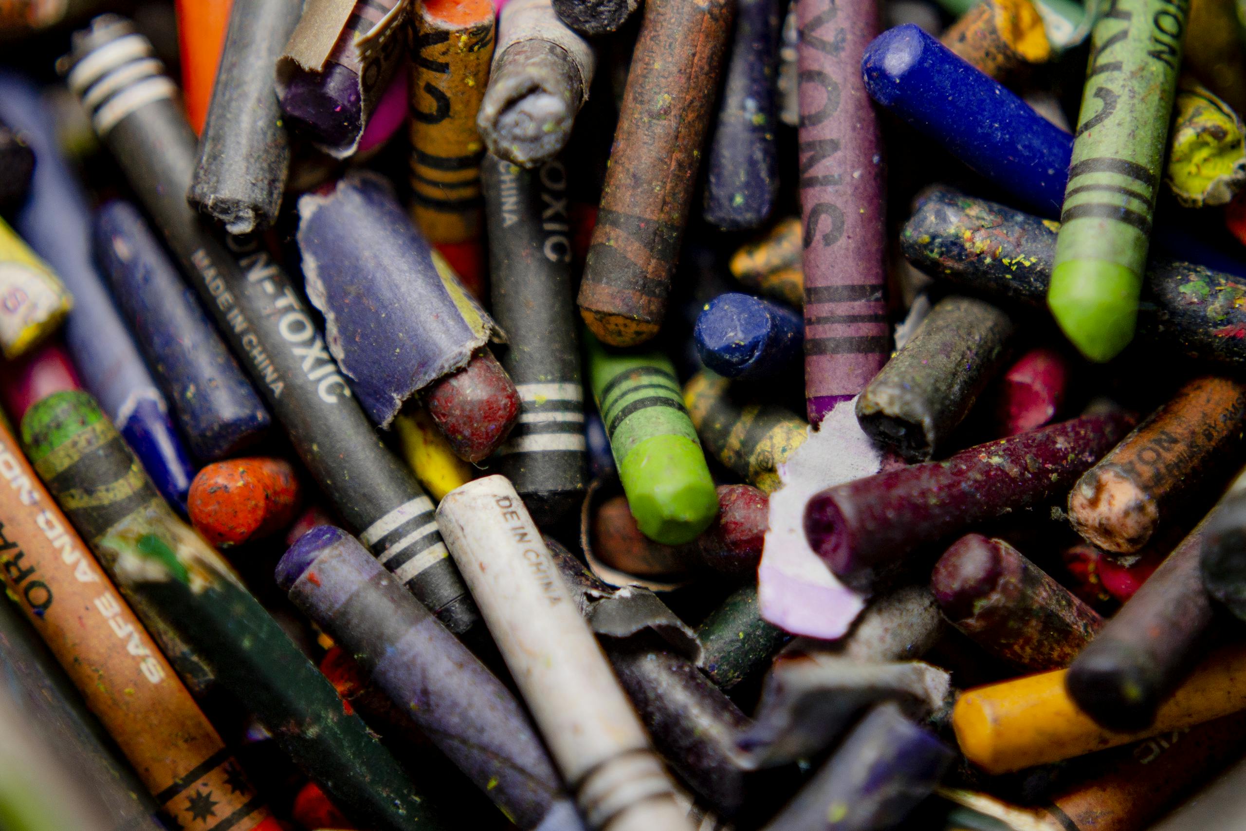 A detailed close-up image showcasing a collection of broken and colorful crayons.